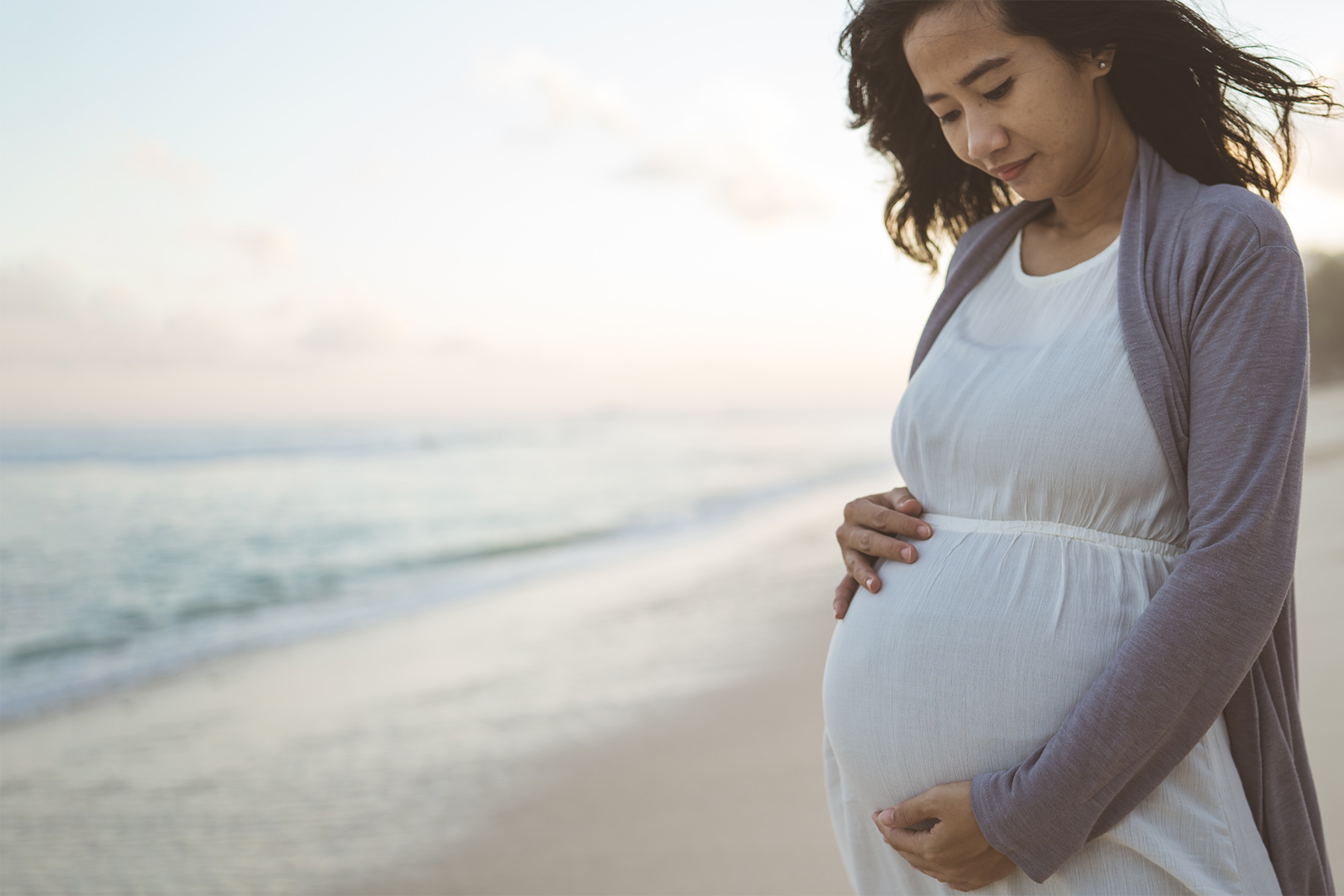 worried pregnant woman stands on the beach worried pregnant woman stands on the beach